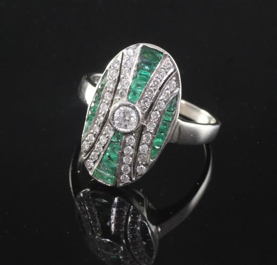 An Art Deco style 18ct white gold, emerald and diamond oval dress ring,